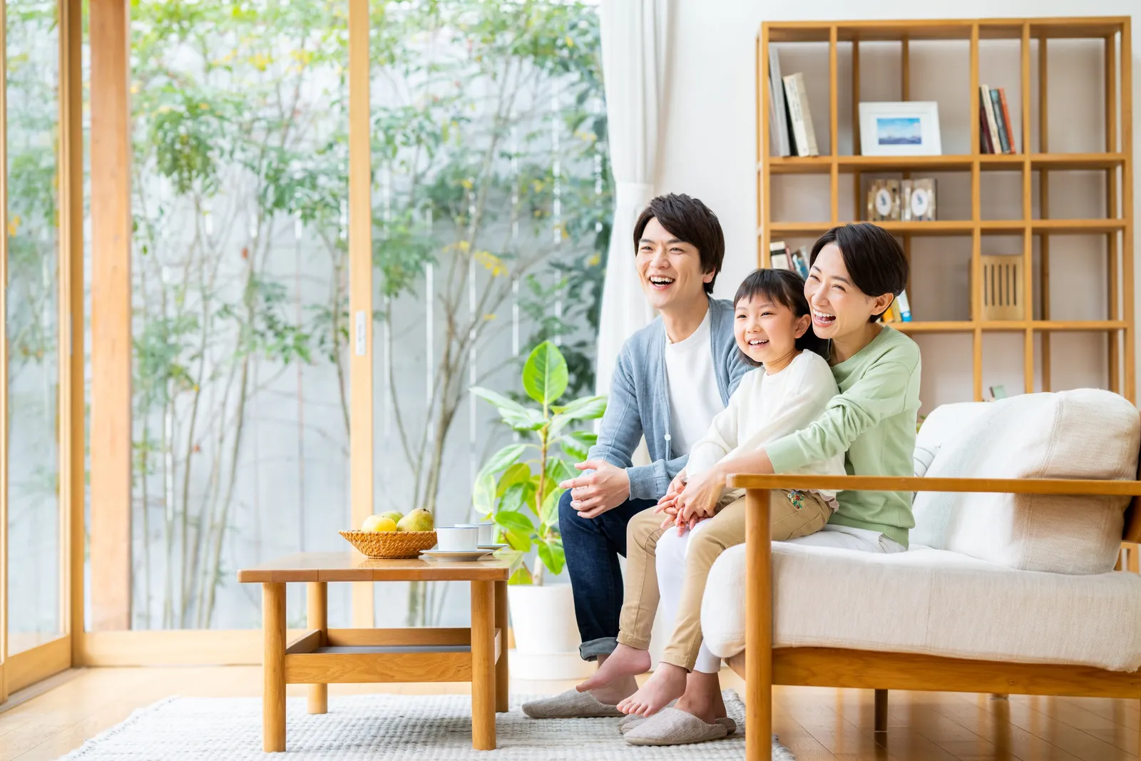 明るいリビングでくつろぐ家族